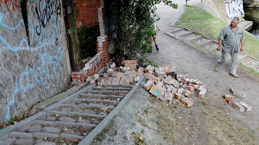 Pavojus: raudonų plytų tvoros dalis nugriuvo tiesiai ant tako.