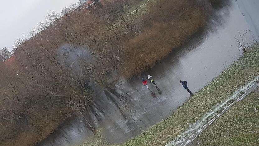 Pavojus: ant vandens telkinio, esančio prie I. Simonaitytės kalno, vaikai ne tik bando ledo storį, bet ir rūko.