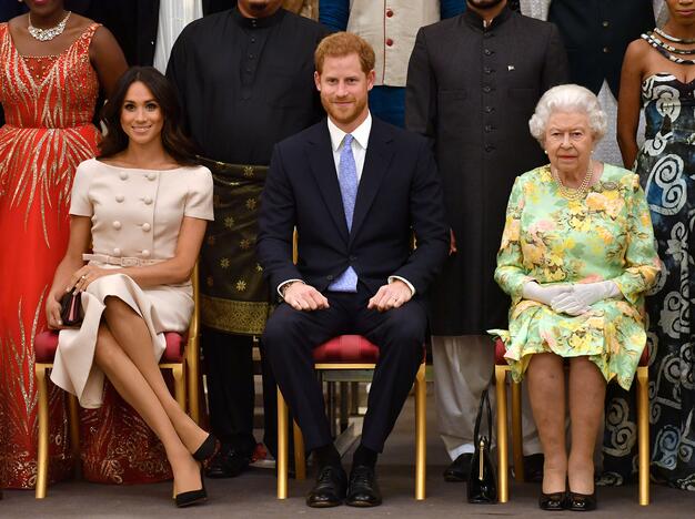 Sasekso kunigaikštienė Meghan (kairėje), Princas Harry (viduryje), Karalienė Elizabeth (dešinėje)