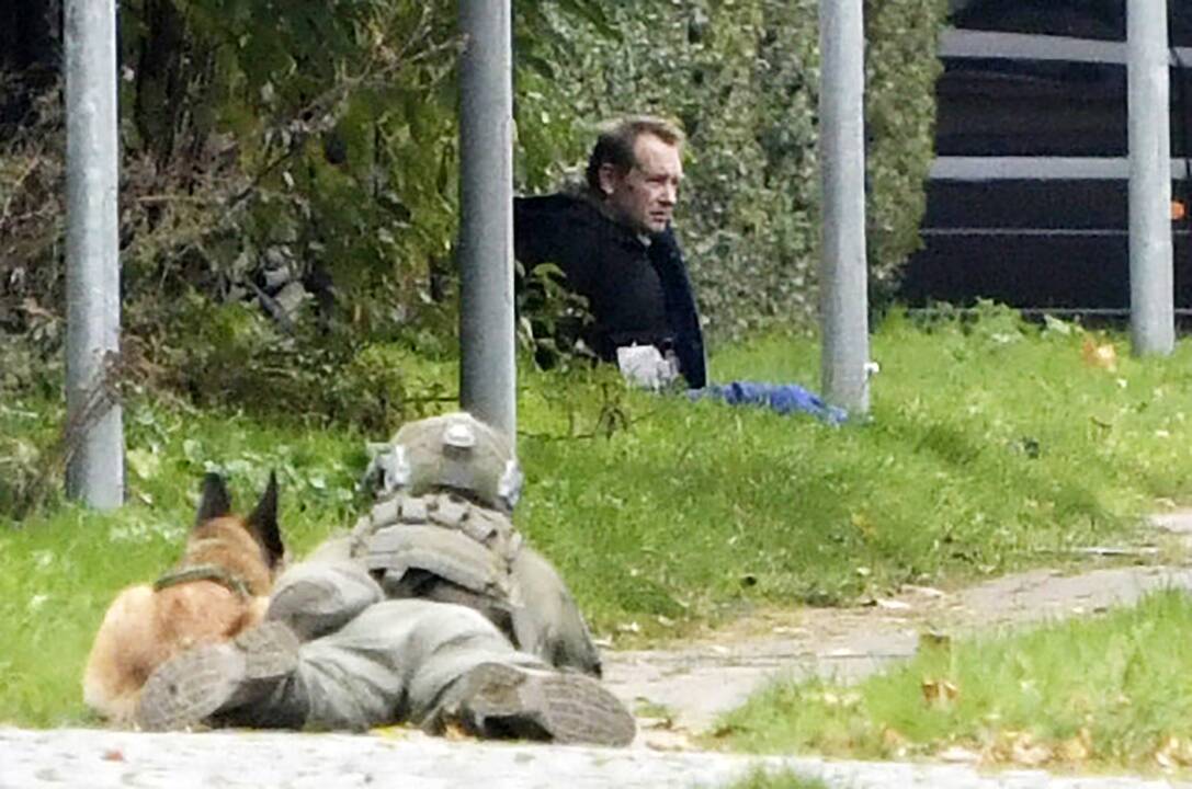 Pareigūnas stebi P. Madseną, kuris grasino susisprogdinti.