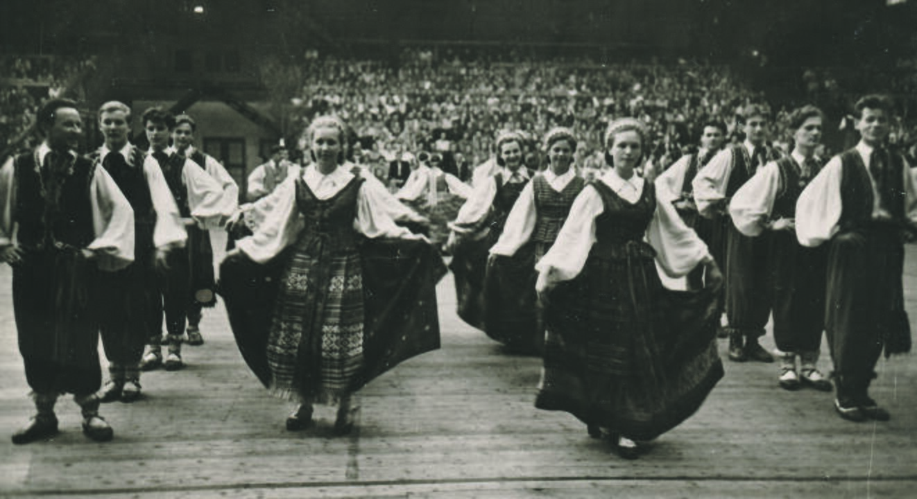 Pradžia: pirmosios dainų šventės 1924 m. dalyviai. Nuo dirigento pakylos sveikinimo kalbą sako Kauno miesto burmistras Jonas Vileišis.