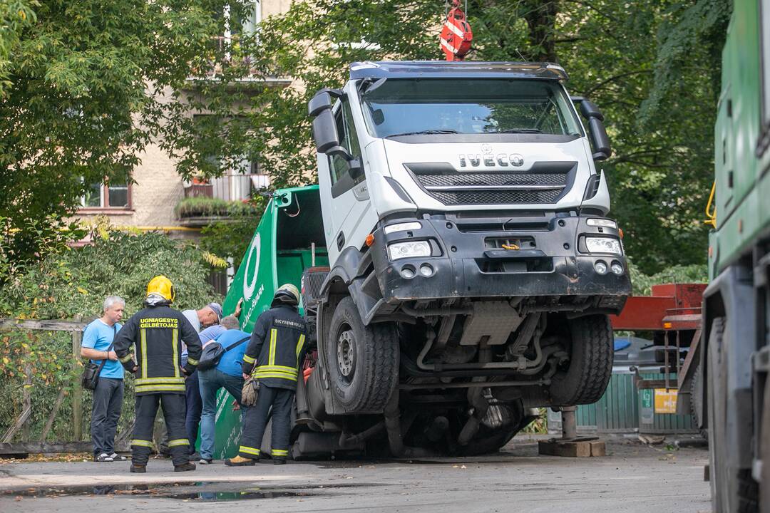 Kauno centre įlūžus asfaltui į duobę įkrito šiukšliavežis