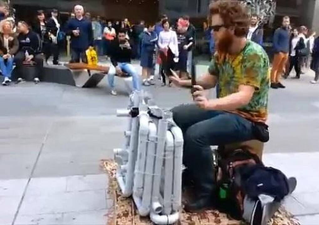 Gatvės muzikantas, grojantis šlepetėmis ir vamzdžiais 