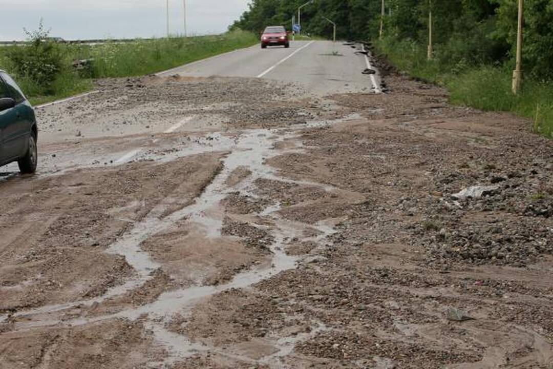 Lietus išardė asfaltą nuovažoje nuo tilto per Nerį