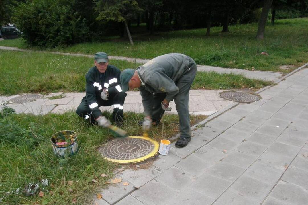 Geltonas šulinio dangtis įspėja apie galima pavojų 