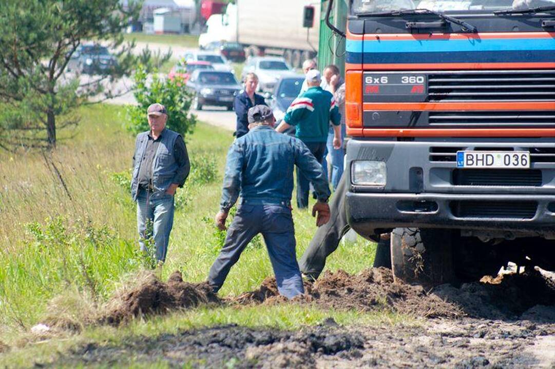 Šalia Gariūnų veždamas dumblą apvirto sunkvežimis