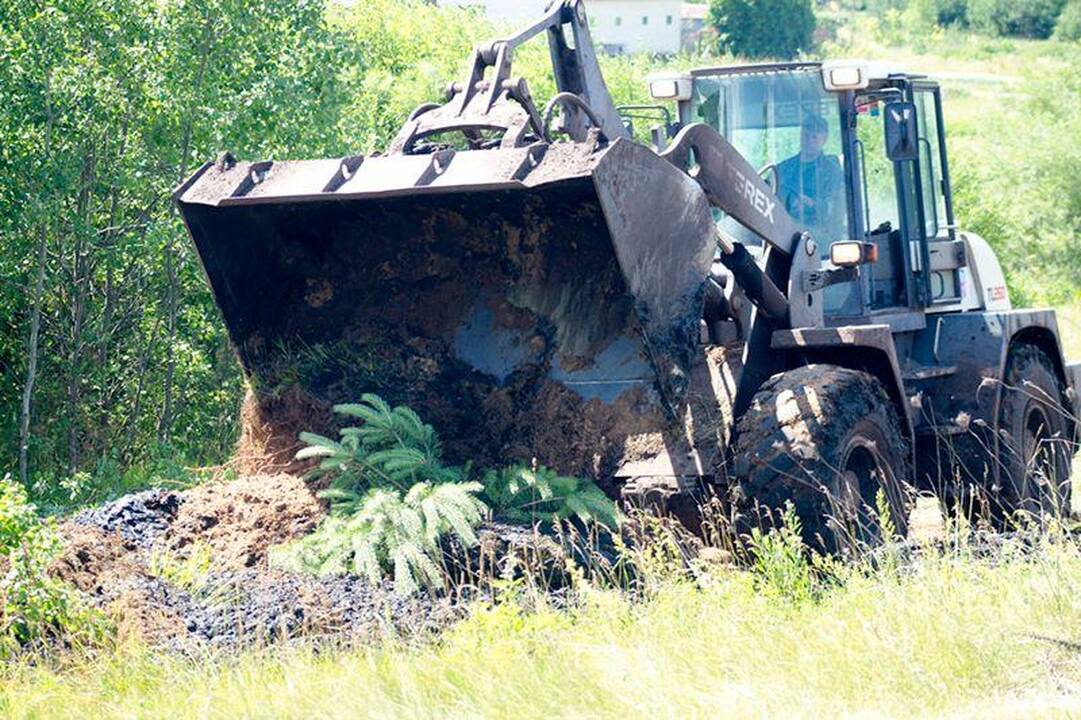 Šalia Gariūnų veždamas dumblą apvirto sunkvežimis