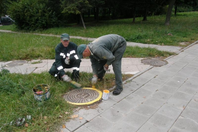 Geltonas šulinio dangtis įspėja apie galima pavojų 
